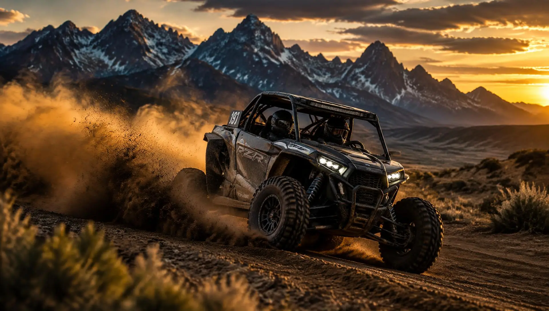 UTV racing on a dirt track below jagged mountains